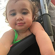 Zamira is registered to the contest to win money with this photo: toddler, child, curly_hair, close_up, selfie, face, arm, stroller, outdoor, sunlight, water_reflection, green_clothing, baby, cute, portrait, person, happy, young_child, skin, daylight