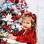 child, girl, red_dress, christmas_tree, holiday, decorations, writing, desk, quill, festive, smile, long_hair, ribbon, indoors, celebration, seasonal, portrait, happy, festivity, toy_car