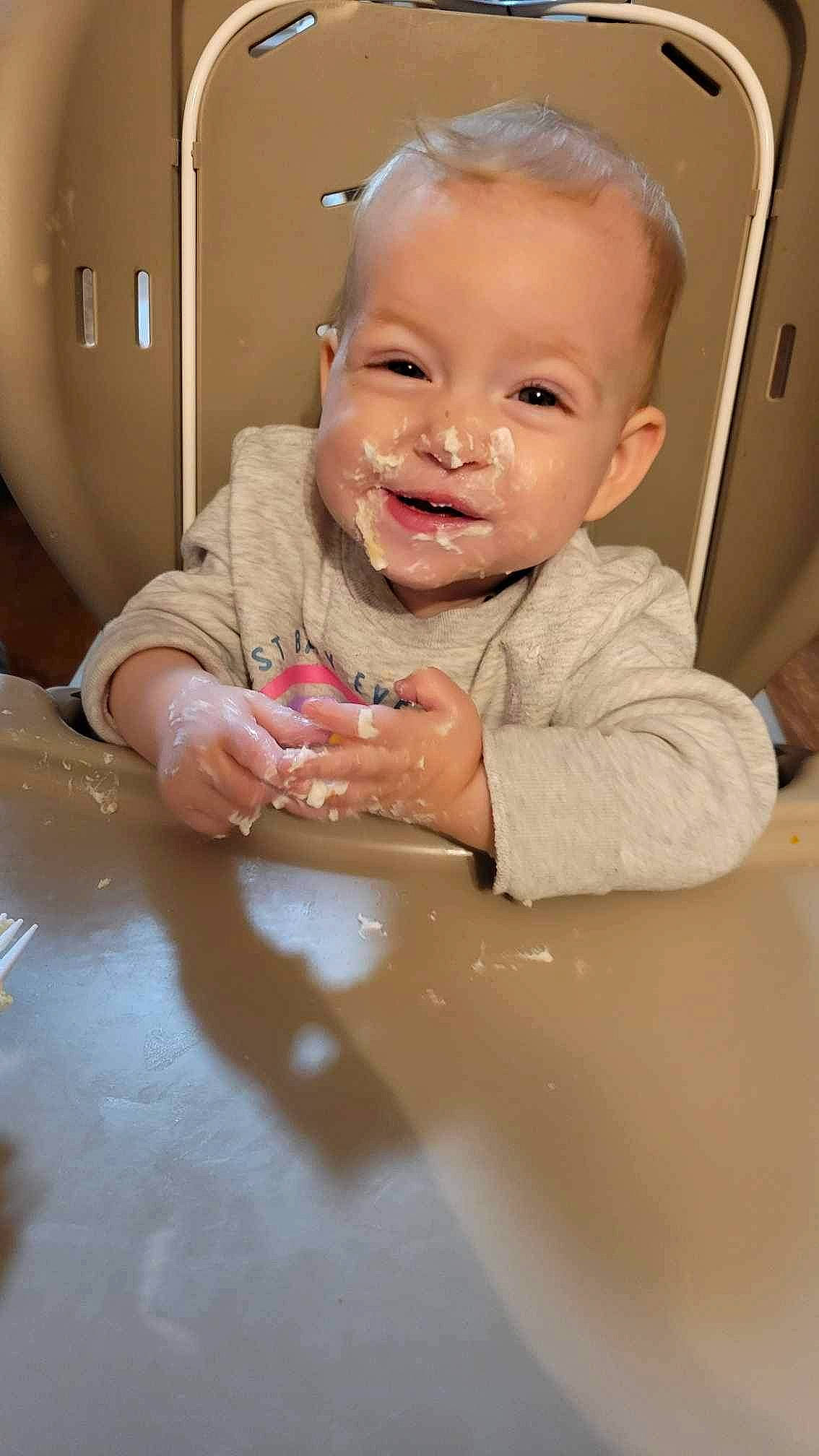 Isabella is registered to the contest to win money with this photo: arm, baby, chair, cheek, child, event, finger, fun, gesture, happy, iris, joy, lip, mouth, nose, person, room, skin, smile, table