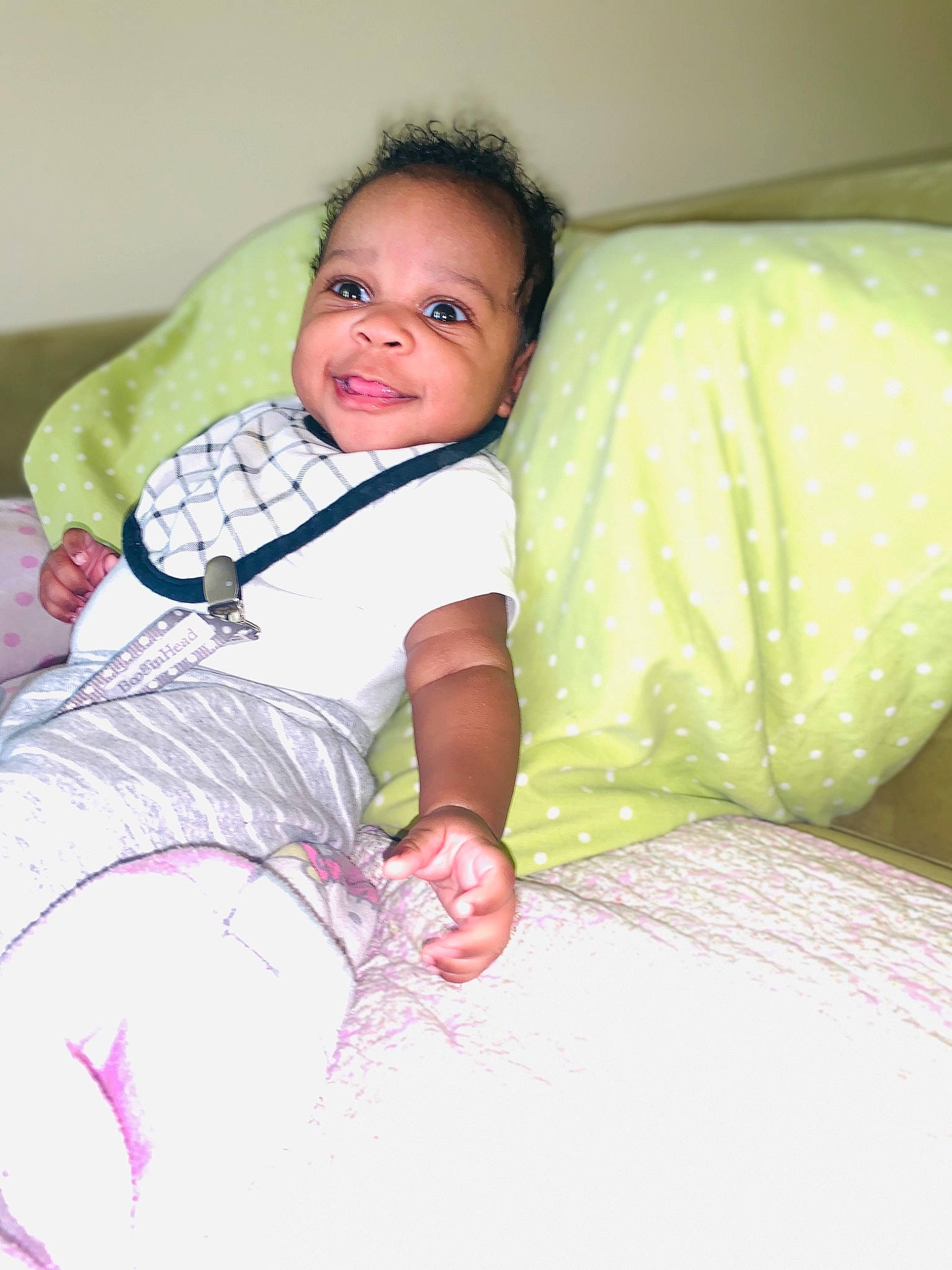 Damarion is registered to the contest to win money with this photo: baby, bed, bedding, child, comfort, couch, event, facial_expression, fun, happy, linens, pattern, person, room, sitting, skin, sleeve, smile, t_shirt, textile