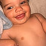 Malakai is registered to the contest to win money with this photo: baby, smile, curly_hair, bottle, blanket, skin, child, infant, happy, cute, portrait, lying_down, hand, face, mouth, tongue, cheek, closeup, expression, soft