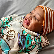 Dreko joined the competition — help win amazing prizes! baby, beanie, cartoon_print, child, clothing, cozy, cute, expression, face, happy, hoodie, indoor, infant, laying_down, person, portrait, smiling, soft_light, striped_hat, tongue_out