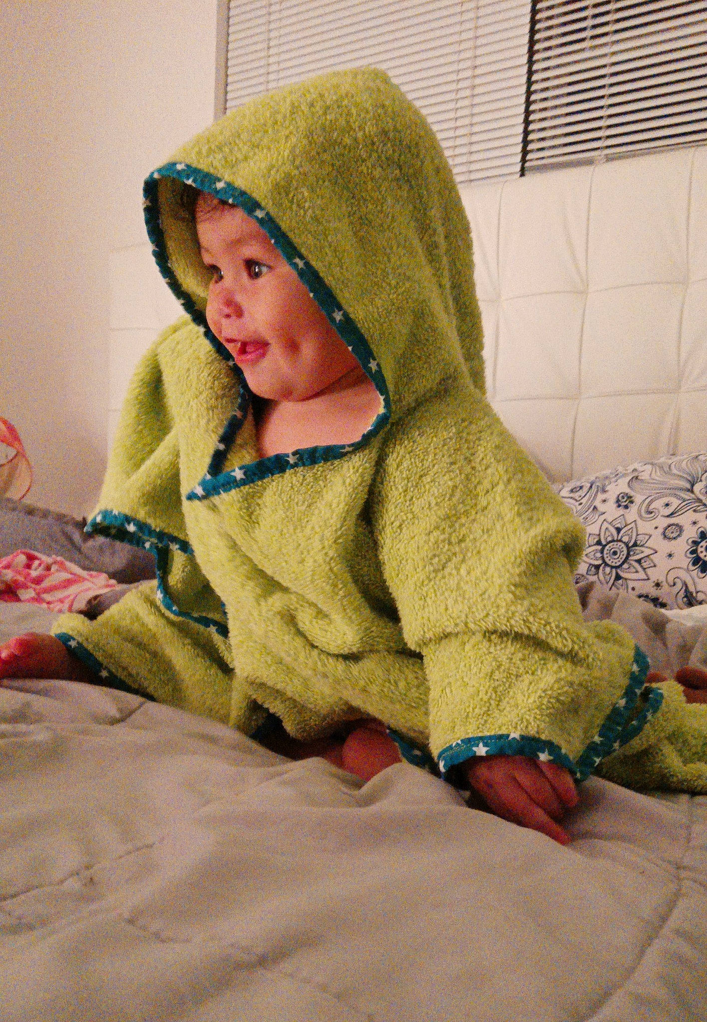 Lea is registered to the contest to win money with this photo: baby, baby_toddler_clothing, bedding, child, comfort, flooring, fur, headgear, headwear, linens, pattern, person, product, room, sitting, skin, sleeve, toddler, vertebrate, wood