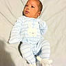 Jamir is registered to the contest to win money with this photo: baby, baby_clothes, blue_stripes, bunny_design, child, curious_expression, cute, footwear, head, indoors, infant, lying_down, newborn, onesie, person, plush_slippers, portrait, sleepwear, small_feet, soft_surface