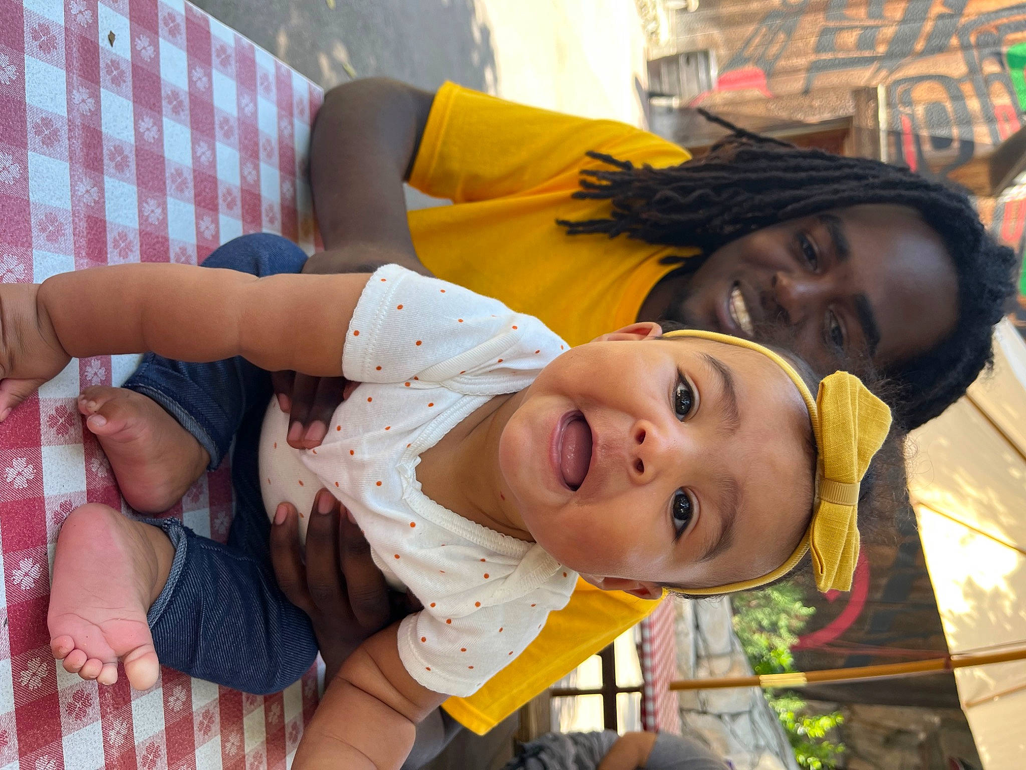 Tiana is registered to the contest to win money with this photo: baby, baby_toddler_clothing, child, fun, happy, joy, laugh, leisure, mouth, pattern, people, person, sitting, skin, smile, toddler, tree, vacation, yellow