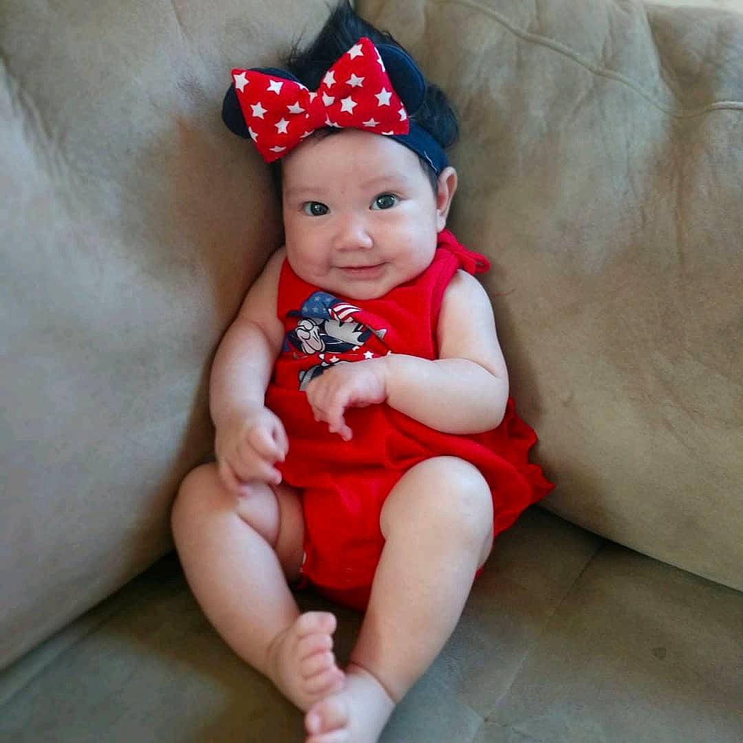 Saraiah joined the competition — help win amazing prizes! baby, baby_toddler_clothing, child, fashion_accessory, hair_accessory, headgear, headwear, person, red, sitting, toddler