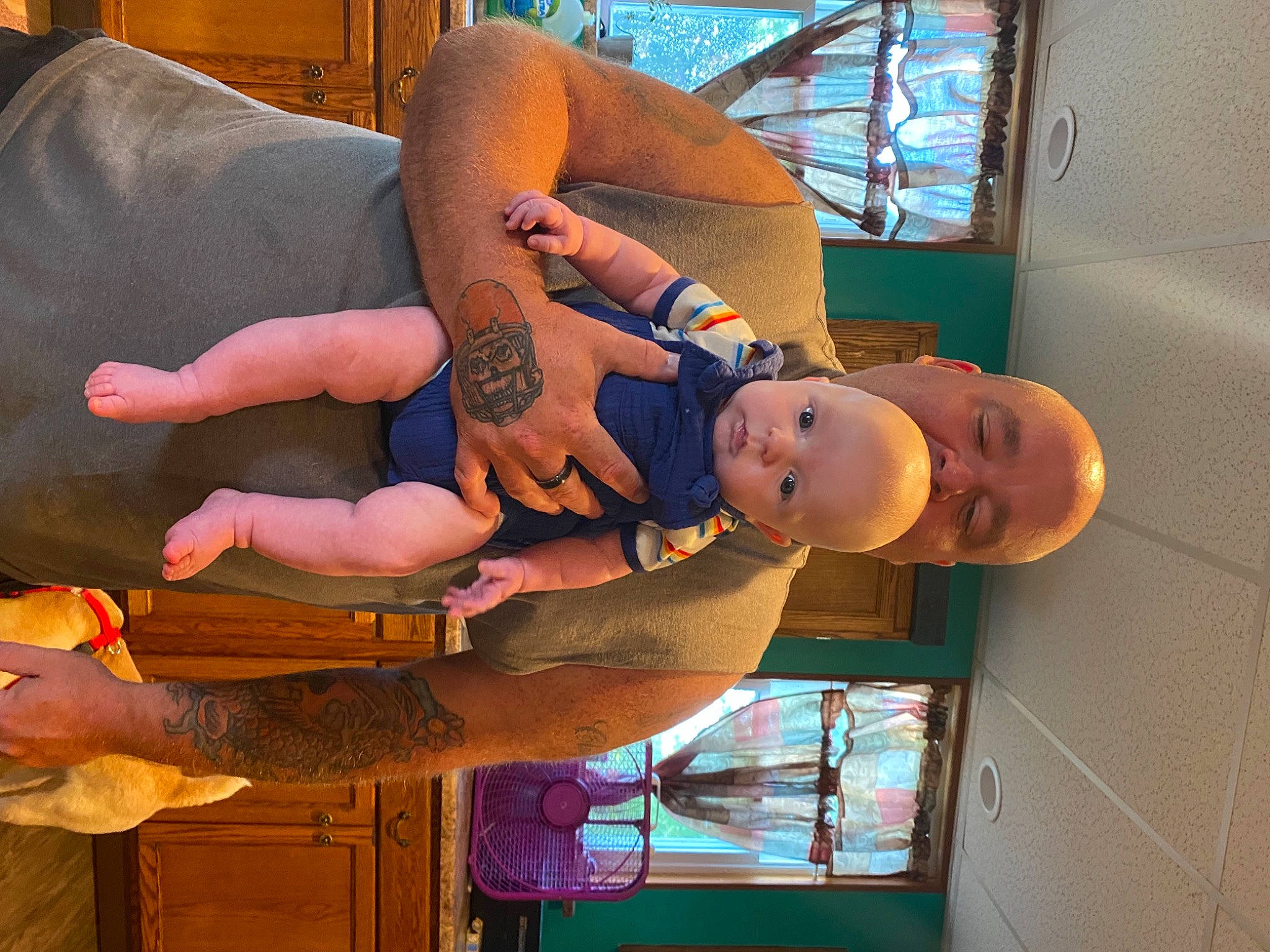 Flynn is registered to the contest to win money with this photo: abdomen, arm, chest, comfort, elbow, finger, fun, gesture, hand, hat, human_leg, knee, leisure, orange, organ, person, tattoo, thigh, toddler, trunk