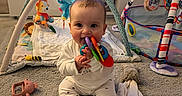 Maisie is registered to the contest to win money with this photo: baby, carpet, chewing, child, clothing, colorful, cute, floor, happy, home, indoor, infant, person, play_gym, playmat, smiling, soft_toys, stuffed_animal, toy, young