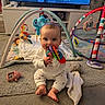 Maisie is registered to the contest to win money with this photo: baby, toy, playmat, carpet, infant, smiling, chewing, play_gym, stuffed_animal, colorful, indoor, child, floor, clothing, cute, happy, young, person, home, soft_toys