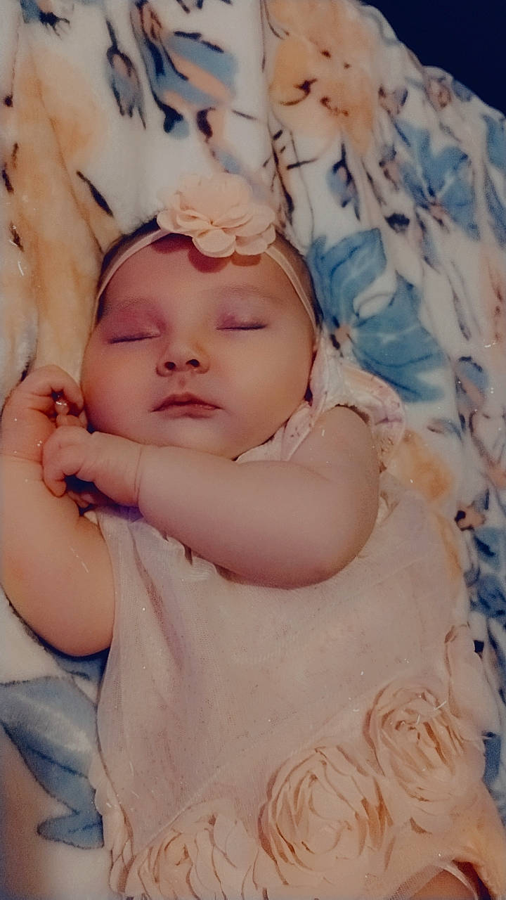 Serenity is registered to the contest to win money with this photo: abdomen, baby, baby_sleeping, baby_toddler_clothing, cheek, chest, child, comfort, eyelash, gesture, happy, iris, linens, lip, pattern, peach, person, pink, portrait_photography, skin