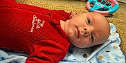 Emerson joined the competition — help win amazing prizes! baby, blanket, carpet, child, christmas, cute, expression, face, floor, holiday, indoors, infant, laying_down, person, polka_dot, portrait, red_clothing, steering_wheel, toy, young