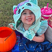 Taytum joined the competition — help win amazing prizes! child, toddler, smiling, hoodie, costume, pumpkin_bucket, outdoor, grass, blanket, blue_dress, pink_sippy_cup, cute, happy, playful, festive, face, person, clothing, hand, toy