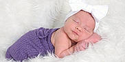 Maisley is registered to the contest to win money with this photo: baby, newborn, infant, sleeping, headband, bow, purple_wrap, white_blanket, fluffy, studio_photo, portrait, rosy_cheeks, peaceful, cozy, soft_texture, hand, closed_eyes, sleeping_pose, newborn_photography, cute