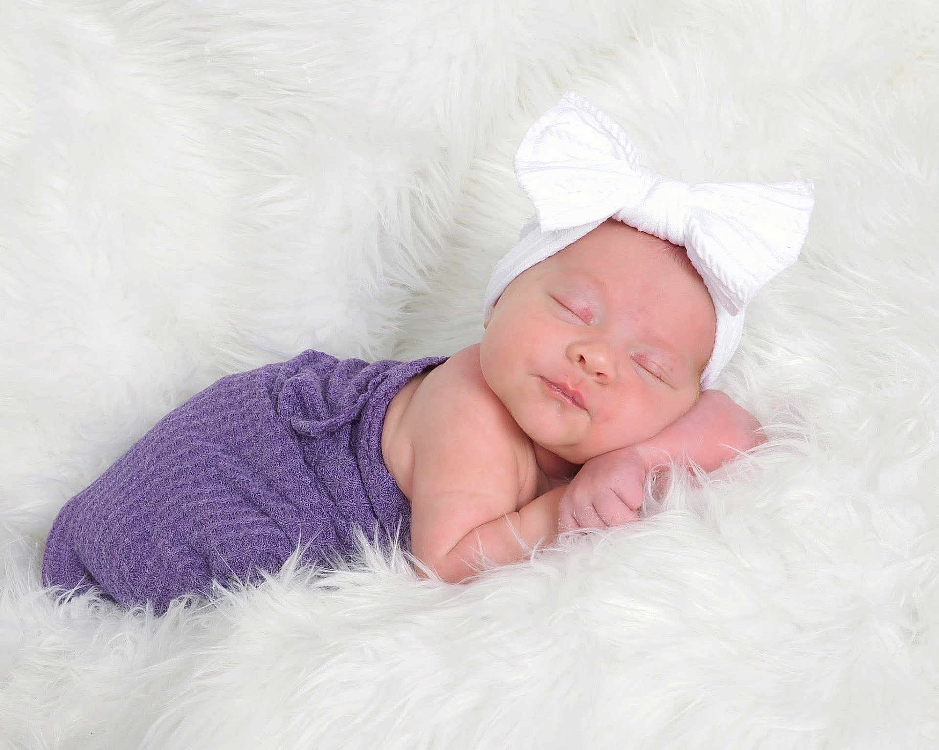 Maisley is registered to the contest to win money with this photo: baby, newborn, infant, sleeping, headband, bow, purple_wrap, white_blanket, fluffy, studio_photo, portrait, rosy_cheeks, peaceful, cozy, soft_texture, hand, closed_eyes, sleeping_pose, newborn_photography, cute