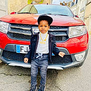 Mael participe au concours pour gagner de l'argent avec cette photo : boy, cap, car, casual, child, confident, fashion, jacket, jeans, necklace, outdoor, portrait, red_car, sidewalk, smiling, sneakers, standing, street, urban, young