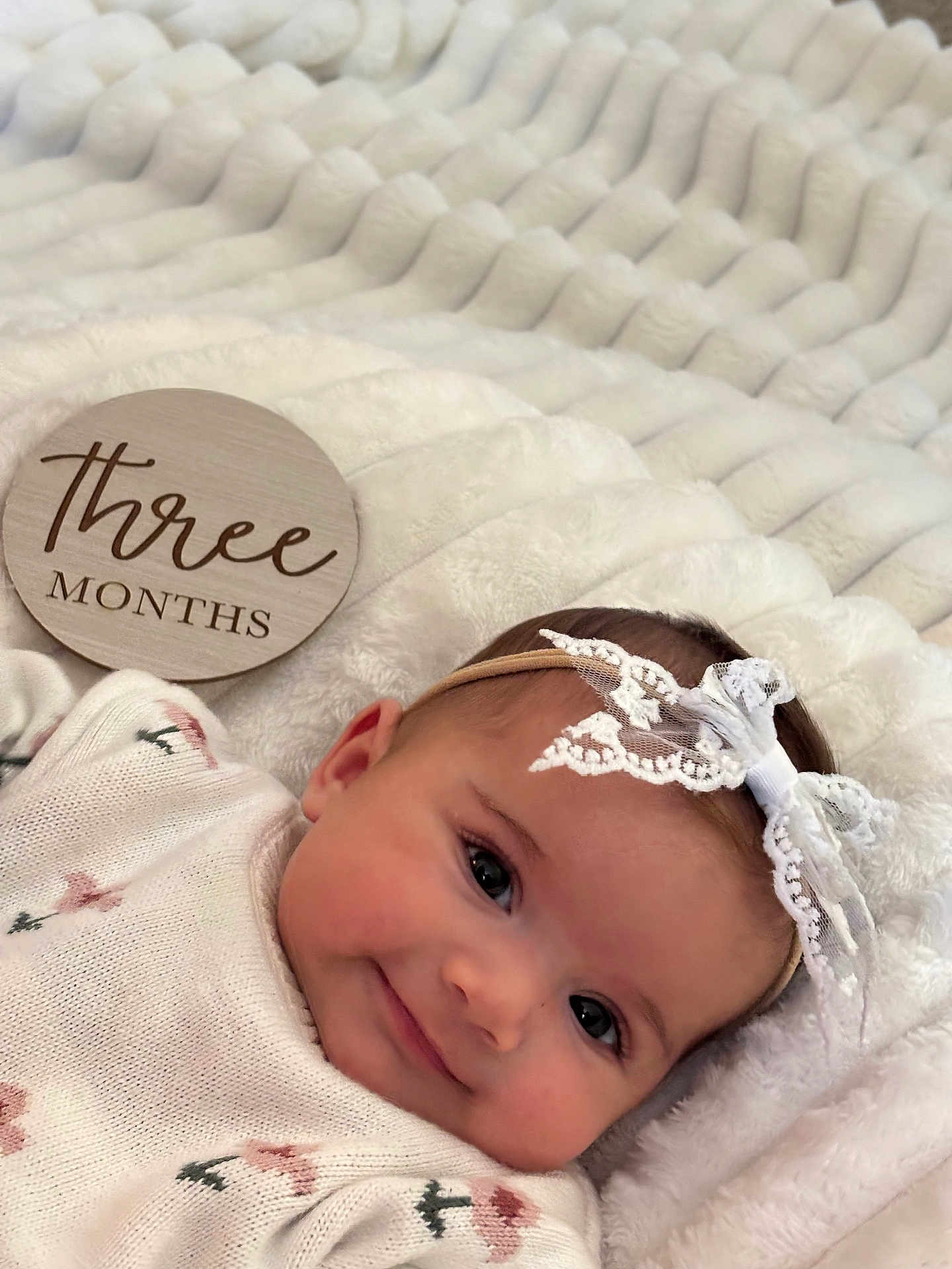 Aria joined the competition — help win amazing prizes! baby, infant, three_months, smile, headband, blanket, soft_texture, cute, lying_down, floral_pattern, clothing, face, close_up, child, adorable, portrait, newborn, happy, cozy, warm