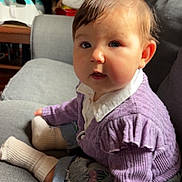 Loëlya participe au concours pour gagner de l'argent avec cette photo : baby, child, indoor, couch, purple_sweater, white_socks, curly_hair, face, blue_eyes, sitting, cozy, furniture, portrait, casual_clothing, cute, chubby_cheeks, home, soft_lighting, denim_pants, curious