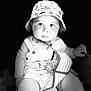 baby, child, hat, bucket_hat, overalls, pacifier, striped_fabric, seated, portrait, black_and_white, cute, infant, face, eyes, hand, clothing, baby_seat, expression, soft_lighting, closeup