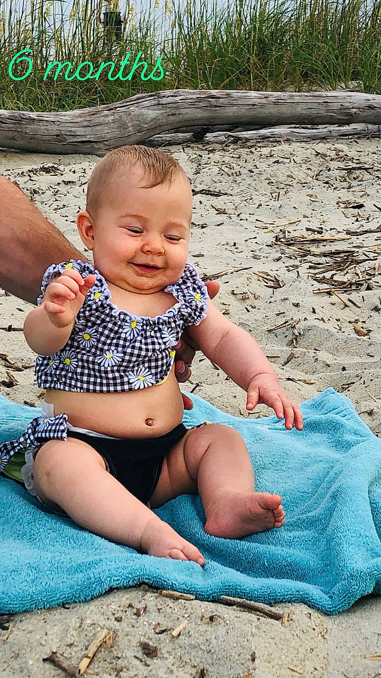 Taylynn is registered to the contest to win money with this photo: baby, baby_toddler_clothing, barefoot, child, design, diaper, fun, joy, leg, pattern, person, play, shorts, sitting, skin, summer, toddler, turquoise, vacation