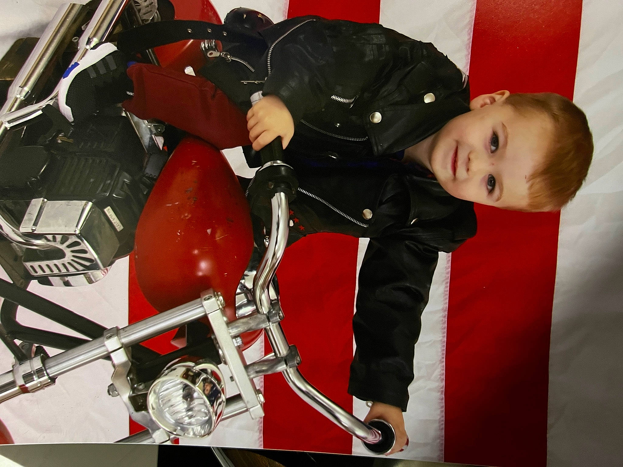 Eric is registered to the contest to win money with this photo: auto_part, automotive_design, automotive_exterior, automotive_lighting, automotive_wheel_system, baby, baby_toddler_clothing, carmine, comfort, hat, human_leg, jacket, joy, lap, machine, motor_vehicle, person, personal_protective_equipment, sitting, sleeve