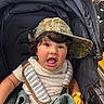 Emmanuel is registered to the contest to win money with this photo: toddler, child, stroller, hat, curly_hair, toy, blanket, clothing, expression, indoor, seatbelt, person, baby, fabric, shopping, store, cute, happy, portrait, colorful