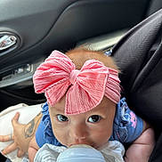 Arissa Victoria joined the competition — help win amazing prizes! baby, infant, bottle, feeding, pink_bow, headband, car_seat, tattoo, hand, blue_clothing, person, closeup, cute, child, indoors, feeding_bottle, looking_up, skin, young_child, sitting
