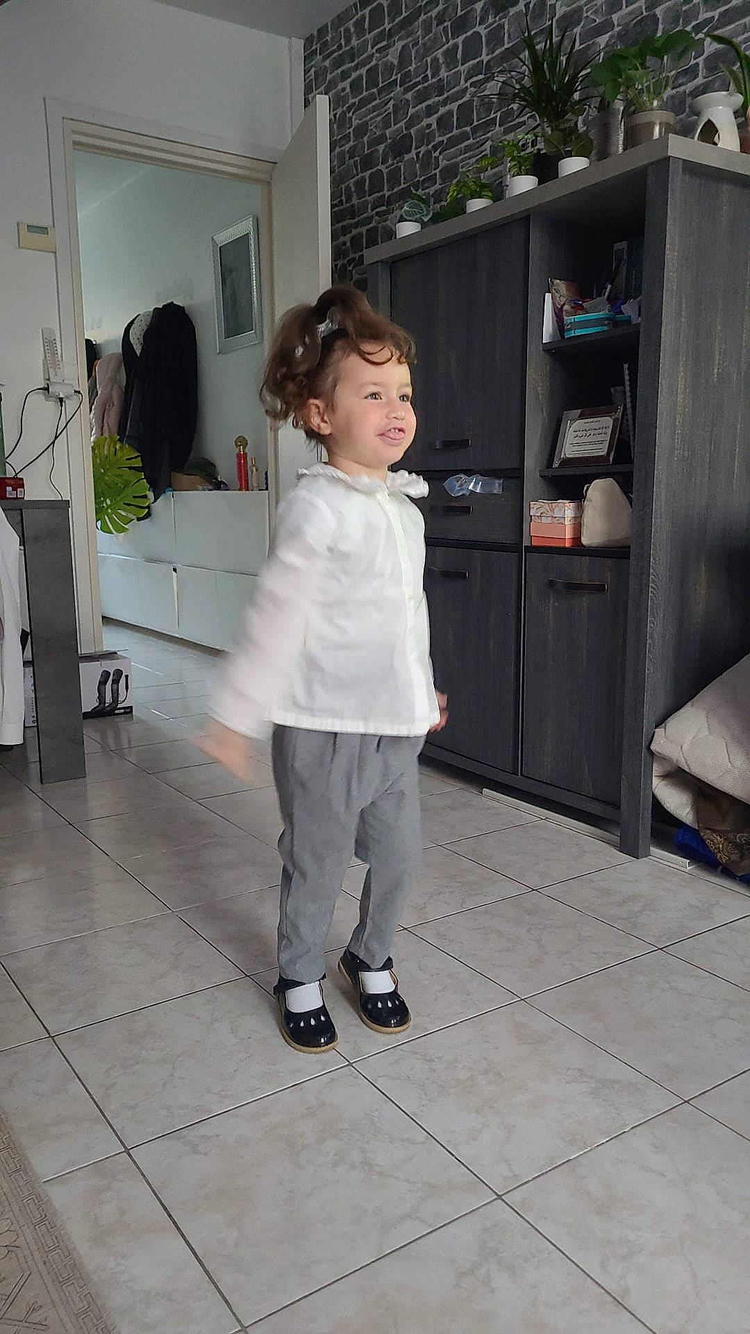 Assya participe au concours pour gagner de l'argent avec cette photo : cabinetry, chest_of_drawers, door, drawer, event, fashion_design, floor, flooring, hardwood, home_appliance, houseplant, joint, kitchen, knee, person, picture_frame, sleeve, standing, toddler, waist