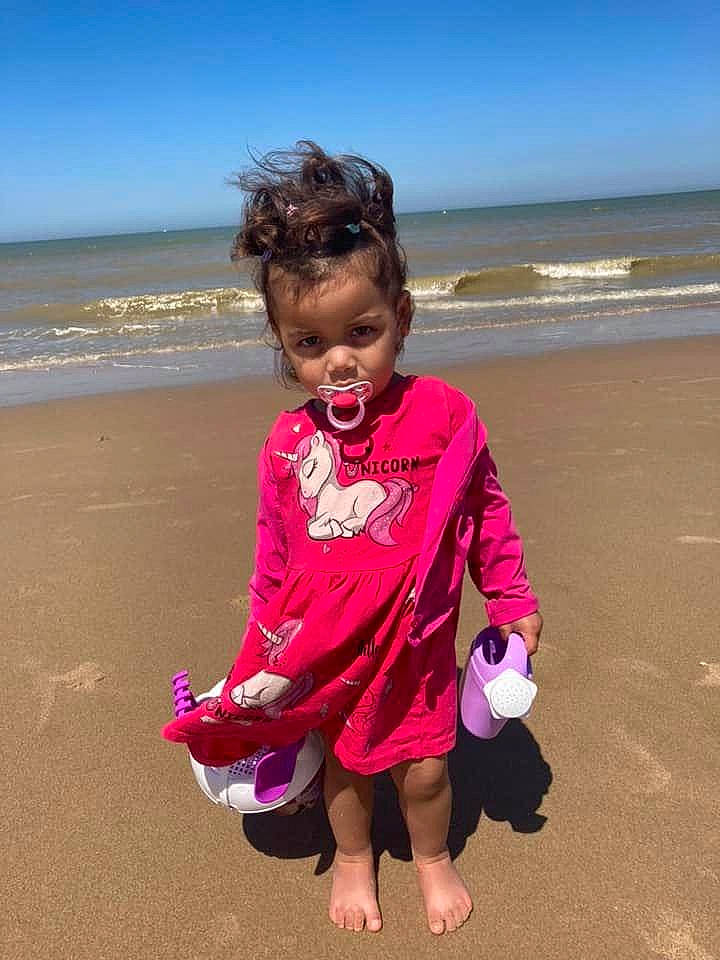 Shayna a rejoint le concours — aidez-le/la à gagner de superbes lots ! baby_toddler_clothing, beach, fun, gesture, hair, happy, holiday, horizon, leisure, magenta, people_in_nature, people_on_beach, person, pink, sand, sky, smile, toddler, travel, water
