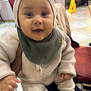 Hadriel participe au concours pour gagner de l'argent avec cette photo : baby, bear_ears, bib, chair, child, clothing, cute, face, floor, hand, happy, indoor, infant, knit_hat, pants, person, seated, shoe, smiling, sweater