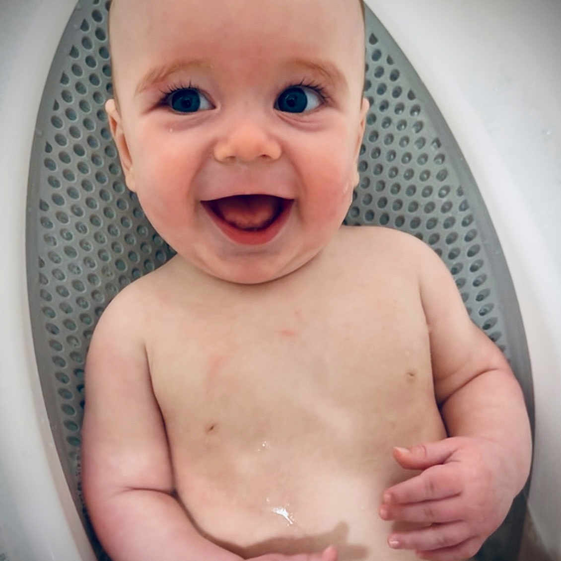Glenn is registered to the contest to win money with this photo: baby, bath_mat, bath_time, bathtub, blue_eyes, child, cute, face, hands, happy, indoors, infant, person, playful, sitting, skin, smile, water, wet, young