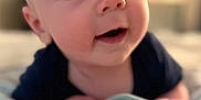 Glenn is registered to the contest to win money with this photo: baby, infant, face, eyes, blanket, soft_focus, curious, mouth_open, lying_down, indoors, skin, head, hand, close_up, portrait, child, young, cute, expression, cozy