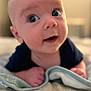 baby, infant, face, eyes, blanket, soft_focus, curious, mouth_open, lying_down, indoors, skin, head, hand, close_up, portrait, child, young, cute, expression, cozy