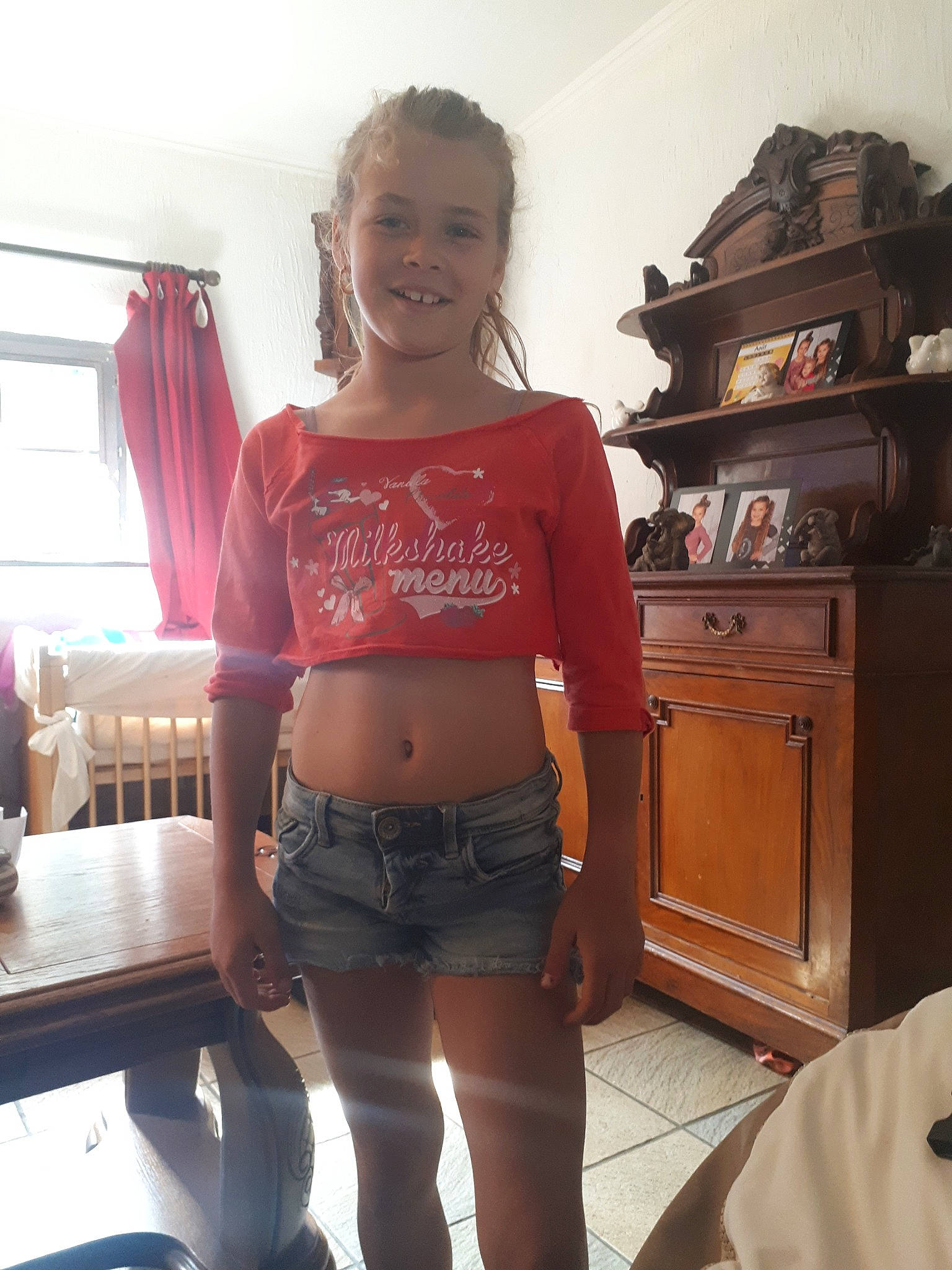 Léa participe au concours pour gagner de l'argent avec cette photo : abdomen, brown_hair, clothing, jeans, joint, joy, leg, long_hair, person, room, shorts, shoulder, t_shirt, thigh, top, waist