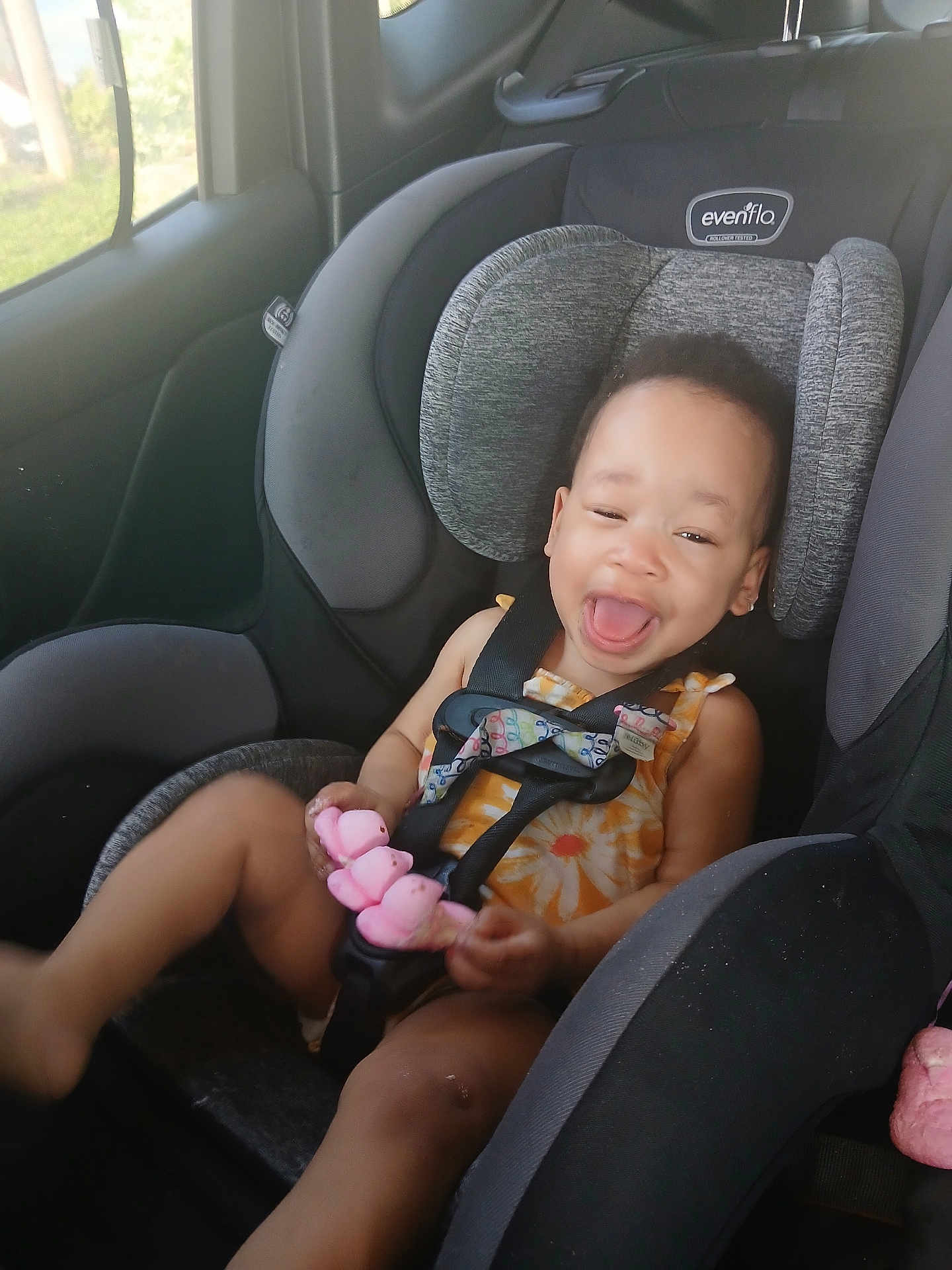 Cori-Christine is registered to the contest to win money with this photo: toddler, child, car_seat, car_interior, smiling, happy, toy, seatbelt, clothing, window, sunlight, headrest, safety, baby, seat, person, vehicle, fun, cute, playful