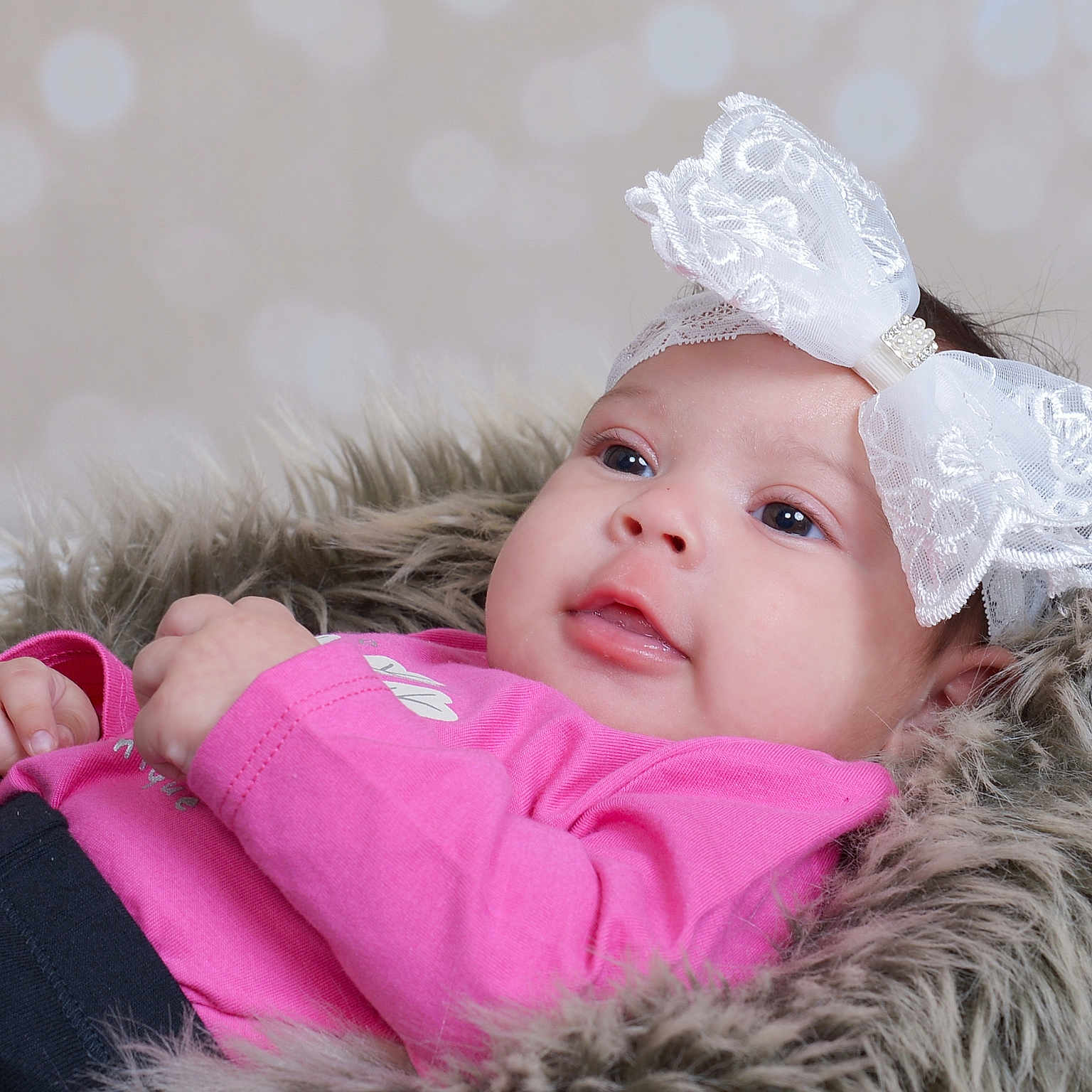 Nasai is registered to the contest to win money with this photo: adorable, baby, child, cute, eyes, face, fashion_accessory, fur_blanket, hands, headband, indoor, infant, laying_down, newborn, peaceful, pink_clothing, portrait, skin, soft_texture, white_bow