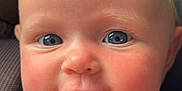 Layla is registered to the contest to win money with this photo: baby, infant, face, blue_eyes, rosy_cheeks, close_up, car_seat, child, cute, young, person, portrait, skin, expression, smile, head, seatbelt, clothing, seat, indoor