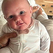 Layla joined the competition — help win amazing prizes! baby, infant, pajamas, face, hand, person, cute, indoors, furniture, dresser, bed, feet, skin, newborn, child, portrait, expression, comfort, clothing, home