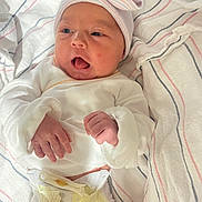 Willow is registered to the contest to win money with this photo: baby, newborn, infant, diaper, hat, bow, blanket, hospital, person, cute, tongue, lying_down, clothing, white, pink, blue, soft, skin, small_hands, bed