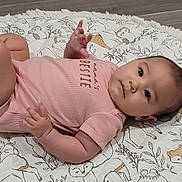 Kallie is registered to the contest to win money with this photo: baby, infant, child, blanket, onesie, pattern, animal_print, flooring, cute, chubby, face, skin, hand, foot, lying_down, indoors, soft, textile, expression, portrait