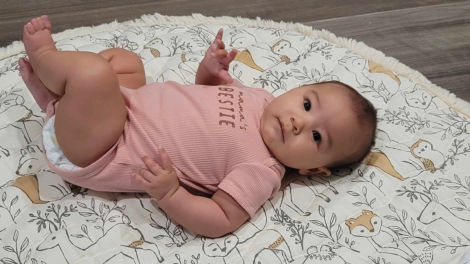 Kallie is registered to the contest to win money with this photo: baby, infant, child, blanket, onesie, pattern, animal_print, flooring, cute, chubby, face, skin, hand, foot, lying_down, indoors, soft, textile, expression, portrait