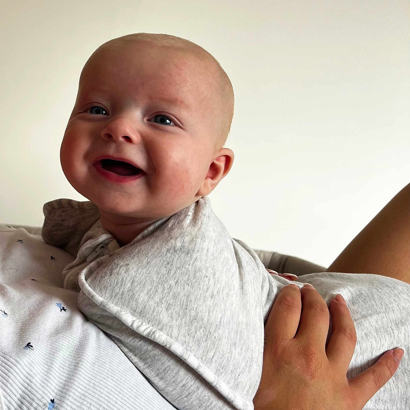 Oakley is registered to the contest to win money with this photo: adult, baby, background, child, clothing, cute, eyes, face, gray, hand, happy, head, holding, infant, newborn, person, portrait, skin, sleeve, smiling