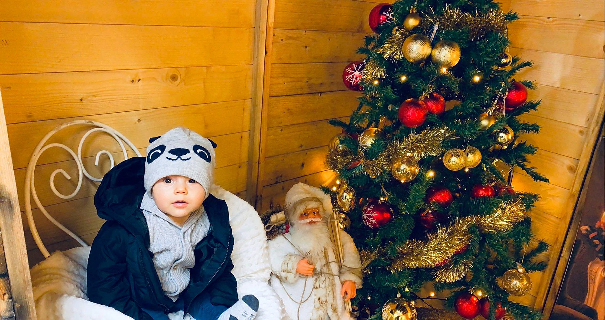 Antonio a rejoint le concours — aidez-le/la à gagner de superbes lots ! baby, baby_toddler_clothing, christmas, christmas_decoration, christmas_eve, christmas_lights, christmas_ornament, christmas_tree, conifer, event, fir, headwear, holiday, holiday_ornament, human, interior_design, ornament, person, pine, pine_family