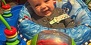 Deandre is registered to the contest to win money with this photo: baby, infant, smile, face, blue, toy, crab, play, seat, child, indoor, happy, clothing, cute, colorful, plastic, activity_center, person, early_childhood, fun