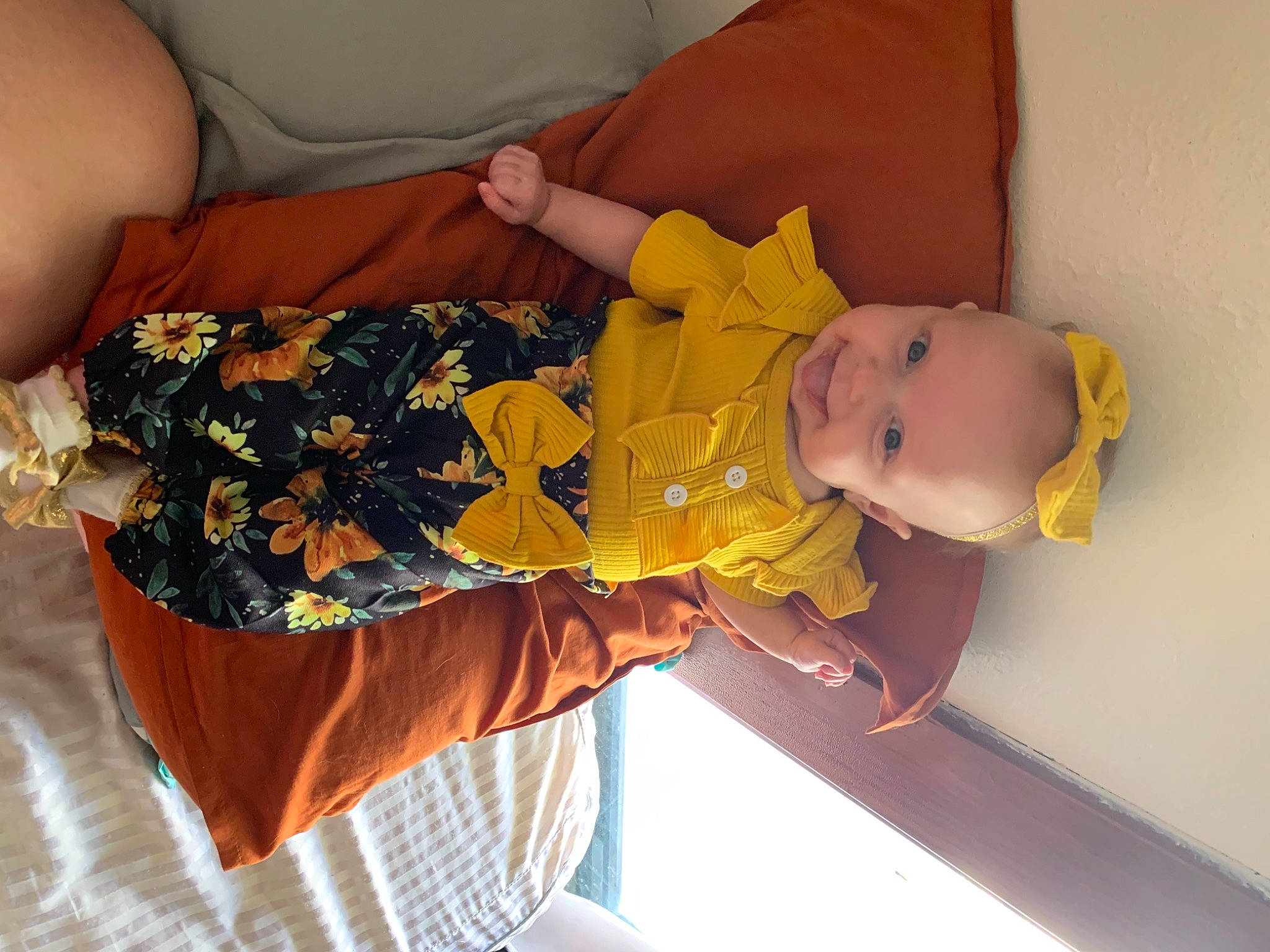 Korah is registered to the contest to win money with this photo: abdomen, arm, baby, baby_products, baby_toddler_clothing, child, cocktail_dress, comfort, finger, hand, human_body, human_leg, orange, pattern, person, product, room, textile, thigh, toddler