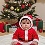 baby, child, santa_claus_costume, christmas_tree, holiday, presents, indoors, festive, red_clothing, white_trim, floor, blanket, decorations, ornaments, lights, celebration, cute, portrait, seasonal, holiday_spirit