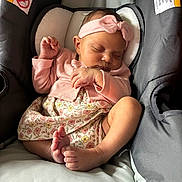 Liliana is registered to the contest to win money with this photo: baby, infant, sleeping, pink_headband, pink_cardigan, floral_dress, baby_seat, cushion, feet, hand, peaceful, indoors, child, cute, adorable, newborn, resting, soft_lighting, portrait, cozy