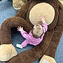 toddler, child, plush_toy, giant_teddy_bear, pink_clothing, carpet, soft_toy, baby, indoors, crawling, cute, floor, stuffed_animal, child_playing, brown, beige, young_child, playtime, toy, infant