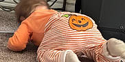 Elowyn is registered to the contest to win money with this photo: baby, crawling, pajamas, pumpkin, orange, striped_clothing, carpet, indoor, child, floor, socks, blur, exploration, cute, toddler, home, furniture, metal_frame, carpeted_floor, infant