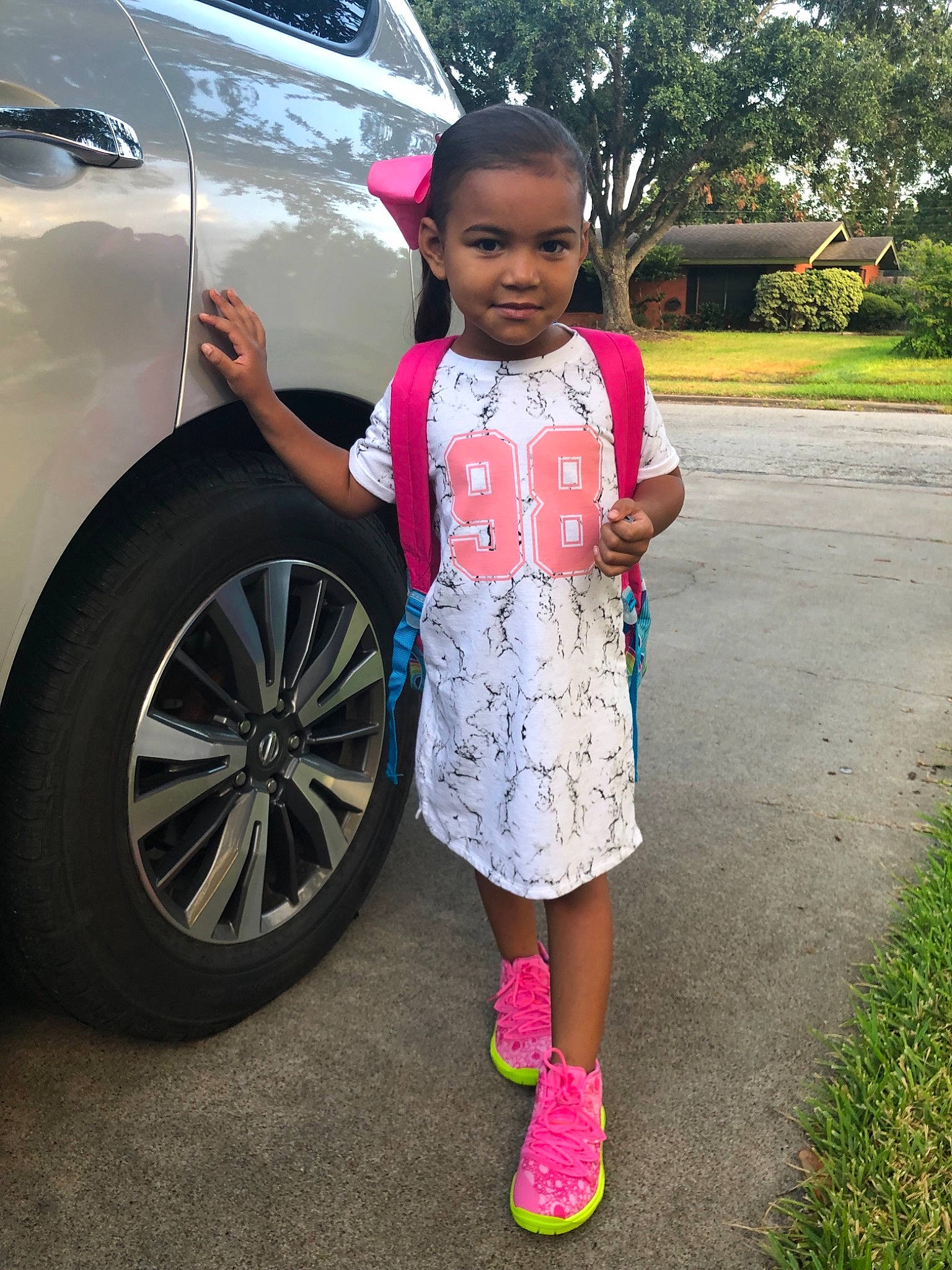 Eve is registered to the contest to win money with this photo: car, child, city_car, crossover_suv, family_car, joy, luxury_vehicle, person, pink, plant, rim, shoe, smile, toddler, vehicle, vehicle_door