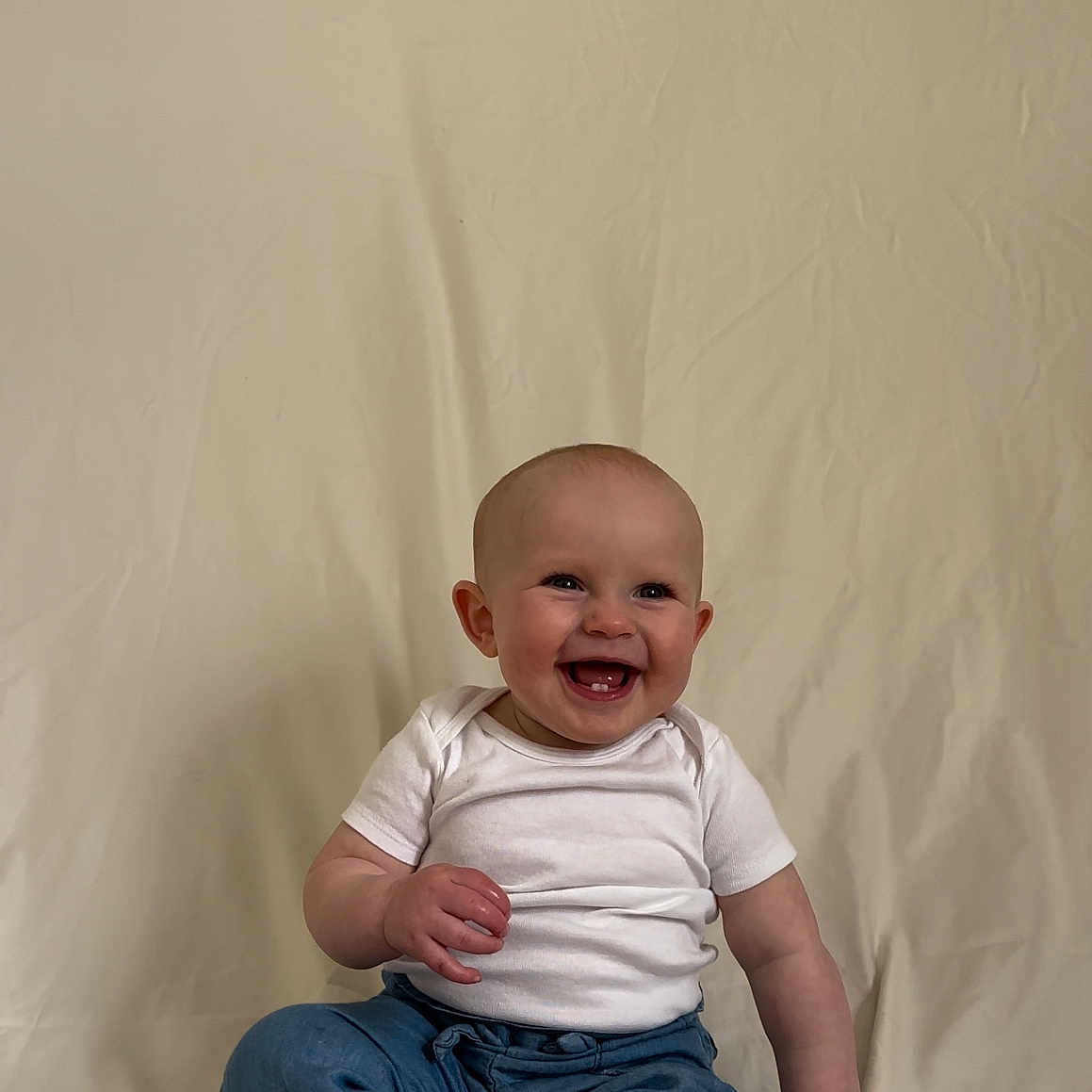 Mavelyn is registered to the contest to win money with this photo: baby, babylaughing, bodypart, clothing, couch, face, finger, furniture, hand, happy, head, jeans, laughing, newborn, pants, person, photography, portrait, sitting, smile